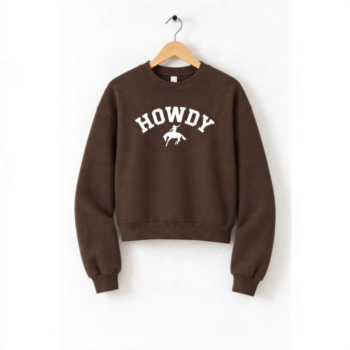 A brown sweatshirt with the word "HOWDY" printed on it, hanging on a wooden hanger.