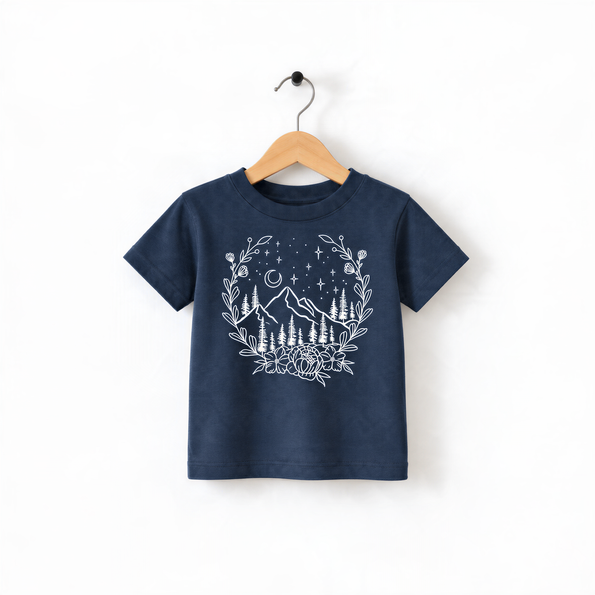 A navy blue t-shirt with a white graphic design depicting a mountain landscape with trees, flowers, and stars.
