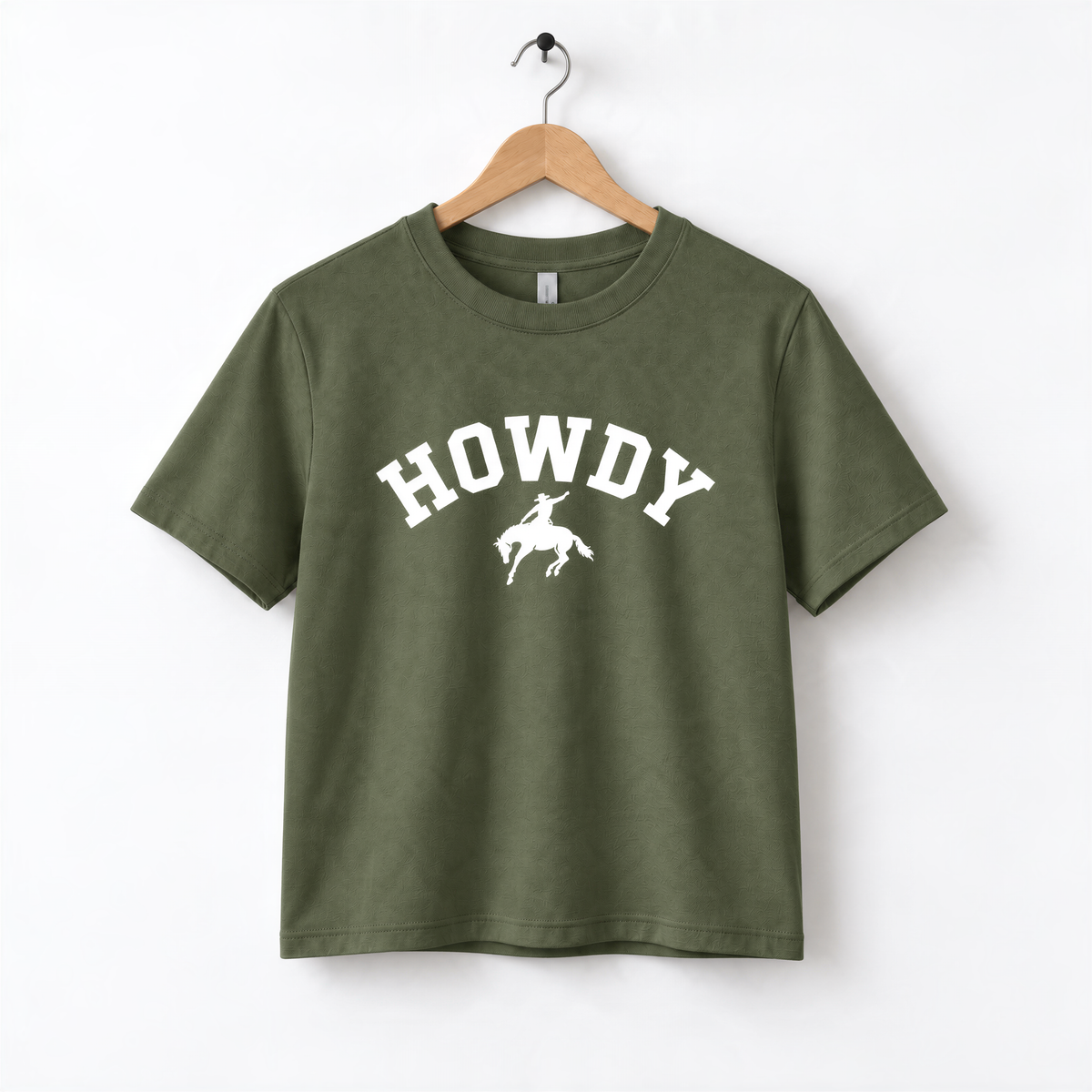 A green t-shirt with the word "HOWDY" printed on it, along with a graphic of a cowboy.