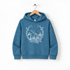A blue hoodie with a white floral design on the front, hanging on a wooden hanger.