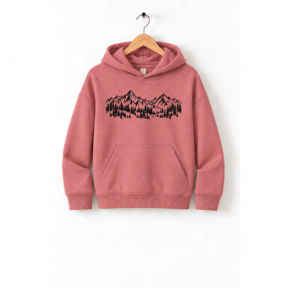 A pink hoodie with a graphic of mountains and trees printed on it, hanging on a wooden hanger.