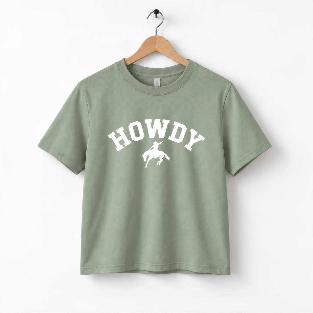 A green t-shirt with the word "HOWDY" printed on it, along with a silhouette of a cowboy.