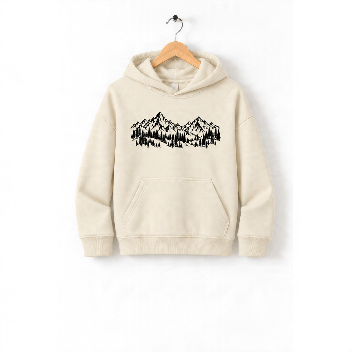 A beige hoodie with a graphic design of mountains and trees printed on it, hanging on a wooden hanger.