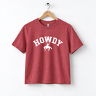 A red t-shirt with the word "HOWDY" printed on it, along with a graphic of a cowboy.