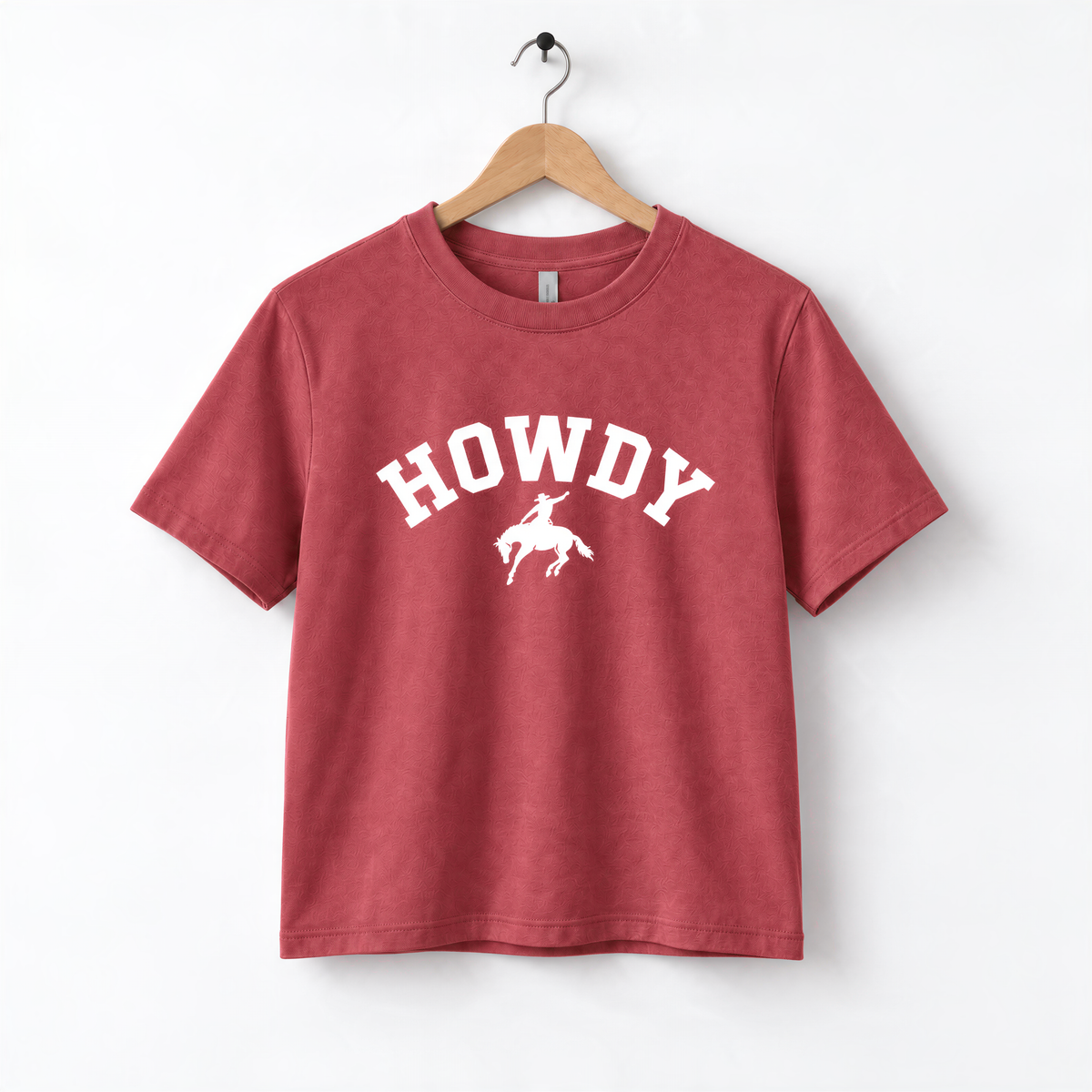 A red t-shirt with the word "HOWDY" printed on it, along with a graphic of a cowboy.
