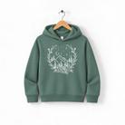 A green hoodie with a white floral design on the front, hanging on a wooden hanger.