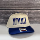 A white baseball cap with blue text on it, placed on a wooden surface.