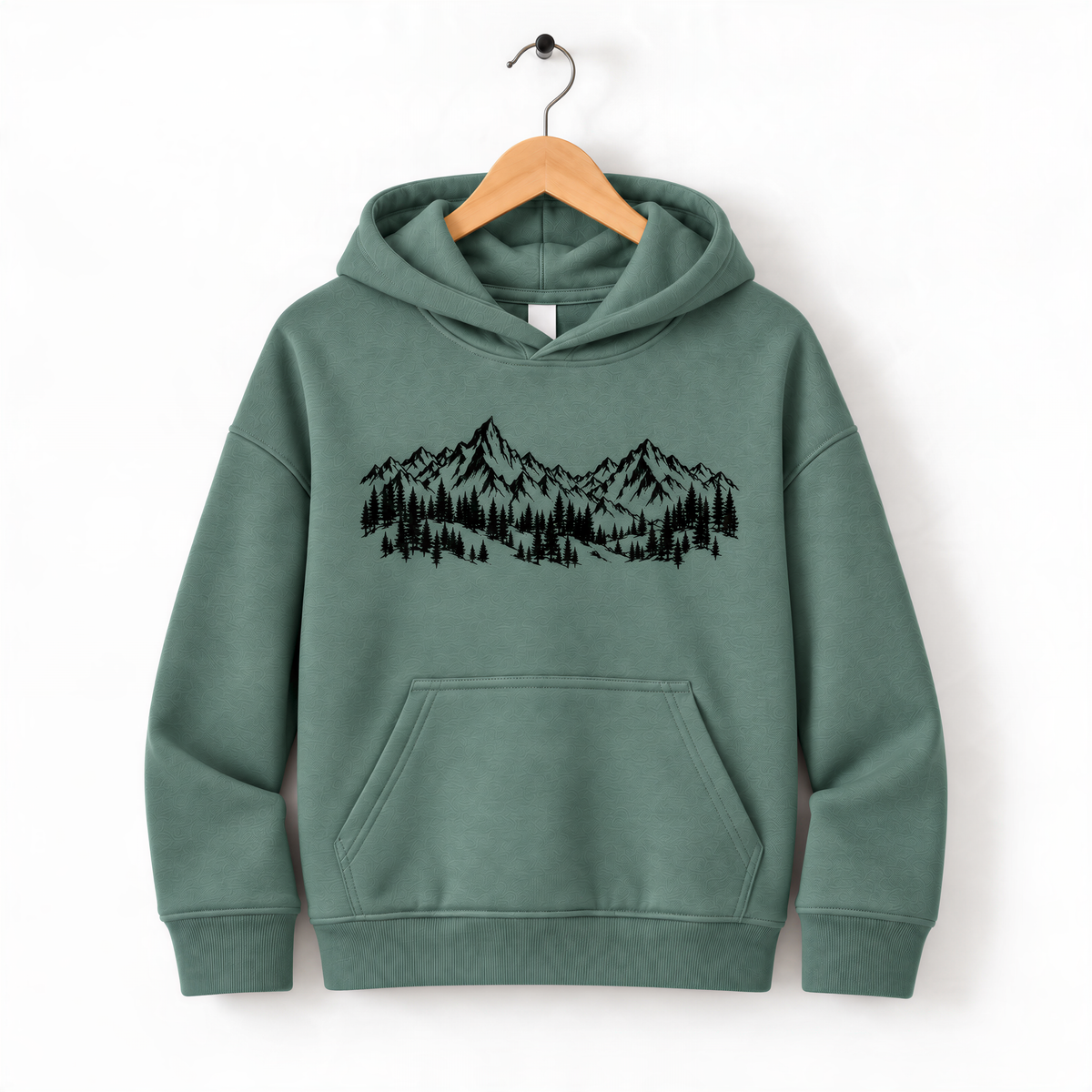 A green hoodie with a graphic of mountains and trees printed on it, hanging on a wooden hanger.