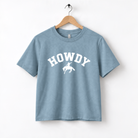 A light blue t-shirt with the text "HOWDY" printed on it, along with a graphic of a cowboy.