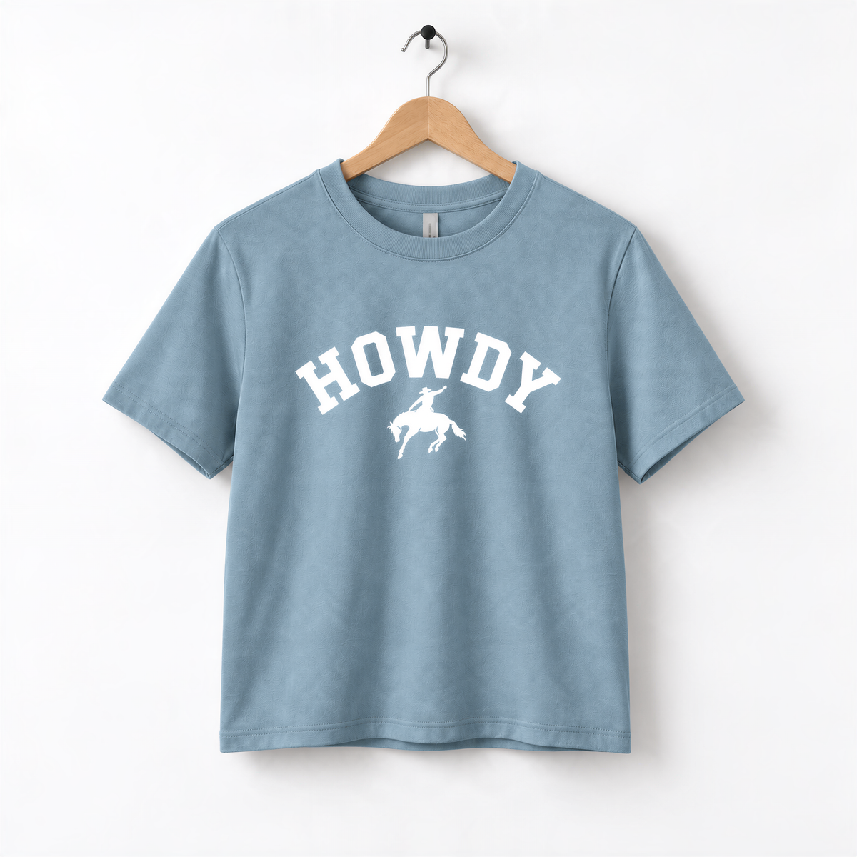 A light blue t-shirt with the text "HOWDY" printed on it, along with a graphic of a cowboy.