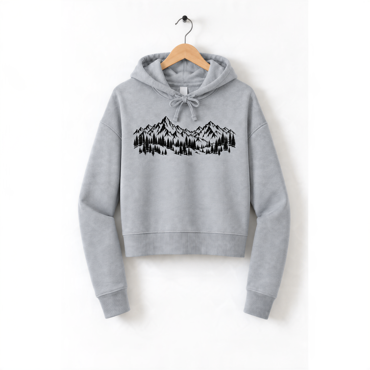 A gray hoodie with a graphic design of mountains and trees printed on it, hanging on a wooden hanger.