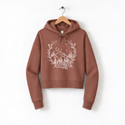 A brown hoodie with a white graphic design depicting a mountain landscape and stars on the front.