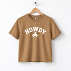 A brown t-shirt with the word "HOWDY" printed on it, along with a graphic of a cowboy.
