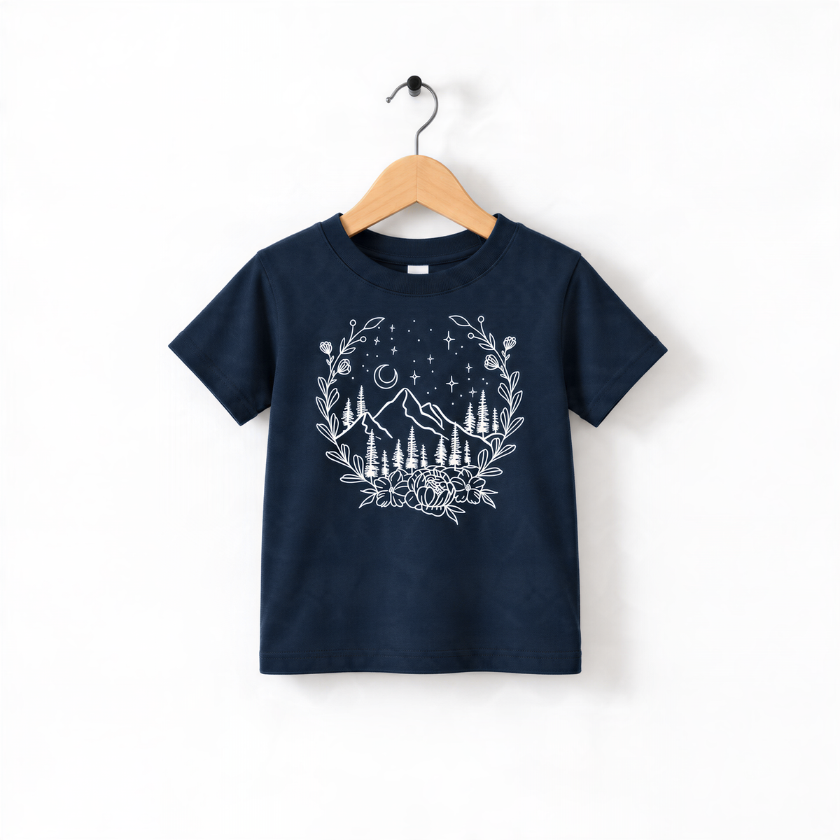 A navy blue t-shirt with a white graphic design depicting a mountain landscape with trees, flowers, and stars.