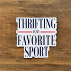 Sticker with 'Thriftling is my favorite sport' sticker on a wooden background