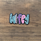 Colorful snake-shaped sticker on a wooden surface