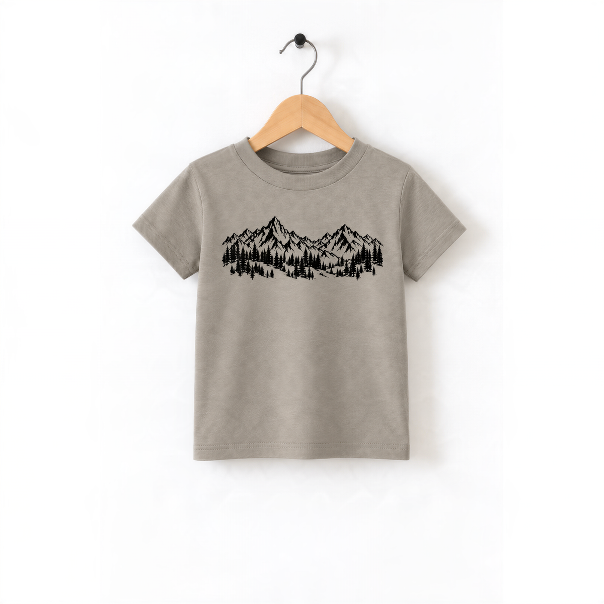 A gray t-shirt with a graphic design of mountains and trees printed on it, hanging on a wooden hanger.