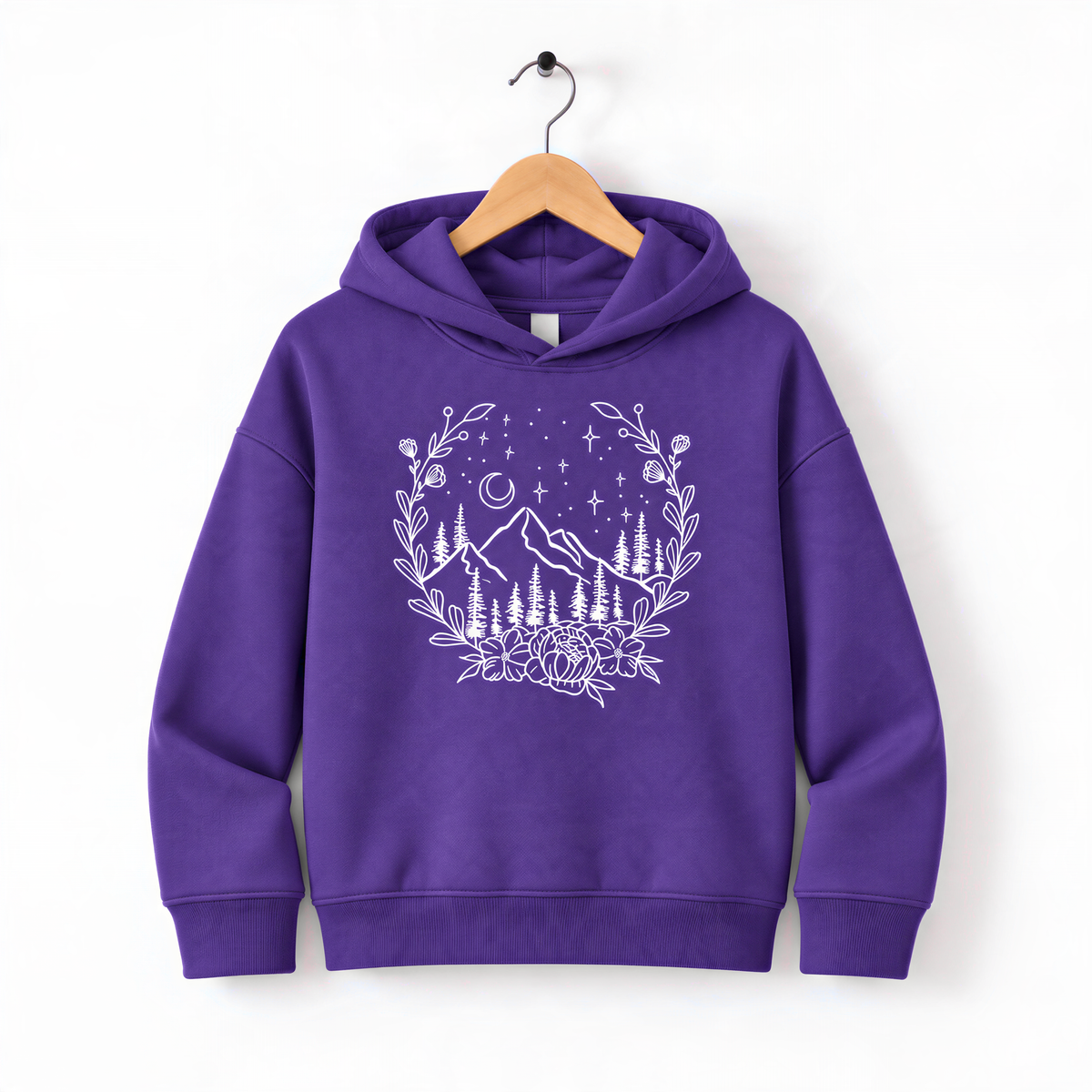 A purple hoodie with a white graphic design depicting a mountain landscape with trees, flowers, and stars on a wooden hanger.
