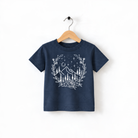 A navy blue t-shirt with a white graphic design depicting a mountain landscape with trees, flowers, and stars.