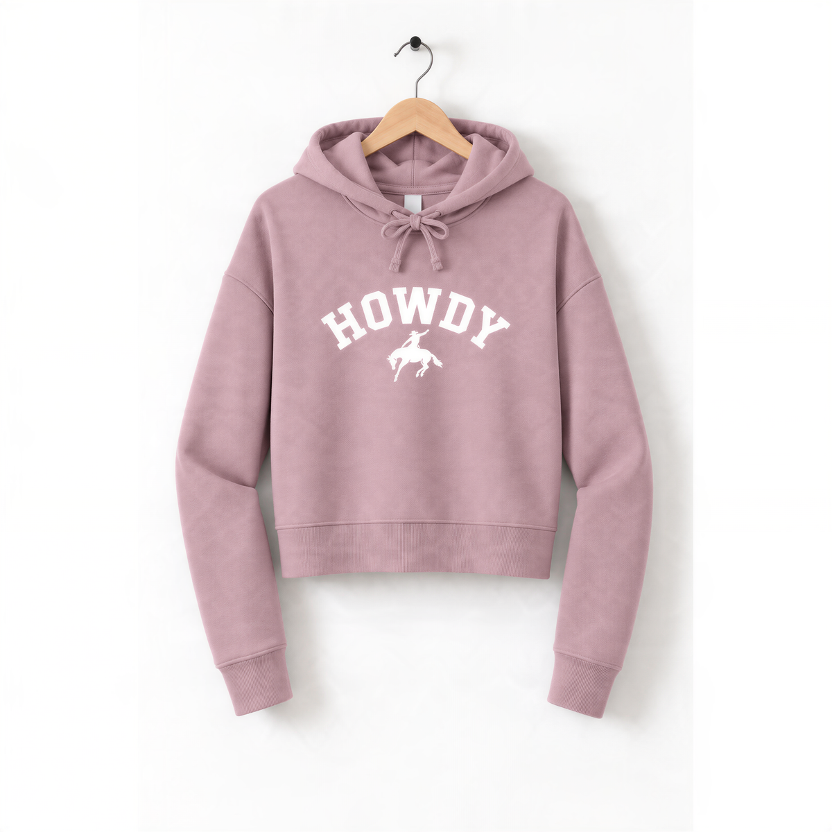 A pink hoodie with the word "HOWDY" printed on it, hanging on a wooden hanger.