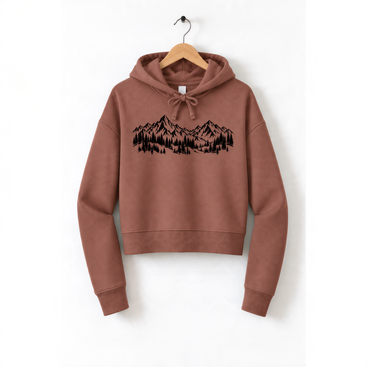 A brown hoodie with a graphic design of mountains and trees printed on it, hanging on a wooden hanger.