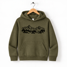 A green hoodie with a graphic of mountains and trees printed on it, hanging on a wooden hanger.