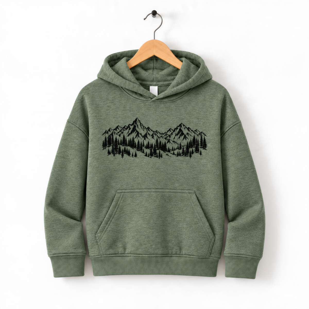 A green hoodie with a graphic of mountains and trees printed on it, hanging on a wooden hanger.